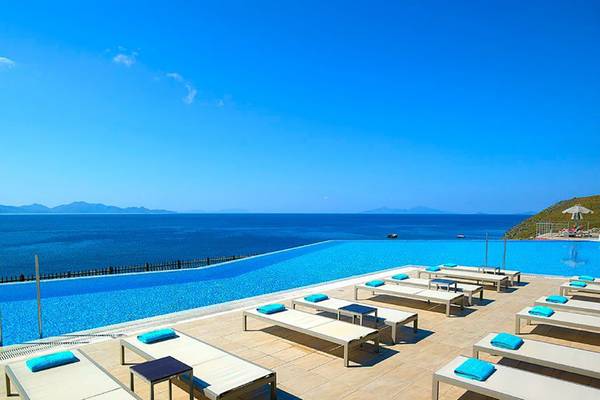 Außenpool mit Liegen und Blick auf das Meer im Michelangelo Resort & Spa.