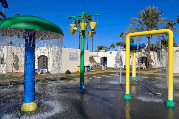 Wasserspielplatz im HD Parque Cristobal Hotel mit bunten Wassersprudlern und Palmen im Hintergrund.