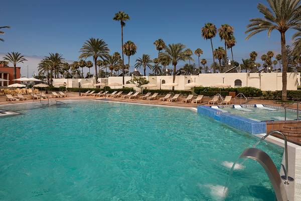 Außenpool des HD Parque Cristobal Hotels mit Sonnenliegen und Palmen
