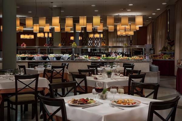 Foto des Innenbereichs des Restaurants im HD Parque Cristobal Hotel mit gedeckten Tischen und Buffet.