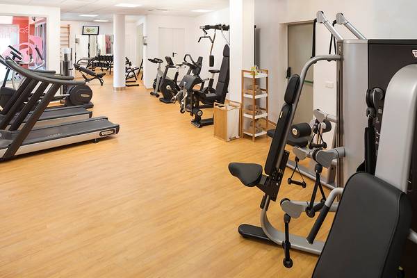 Fitness-Center im HD Parque Cristobal Hotel mit verschiedenen Trainingsgeräten und Holzböden.