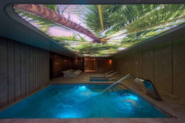 Innenpool im HD Parque Cristobal mit Palmenbaumprojektion an der Decke.