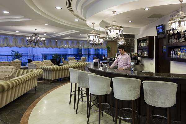 Ein Barkeeper serviert Getränke an der Bar des Roma Beach Resort & Spa.
