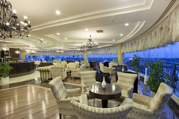 Lounge-Bereich im Roma Beach Resort & Spa mit großen Fenstern und moderner Einrichtung.