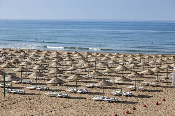 Strand des Roma Beach Resort & Spa mit vielen Sonnenschirmen und Liegen