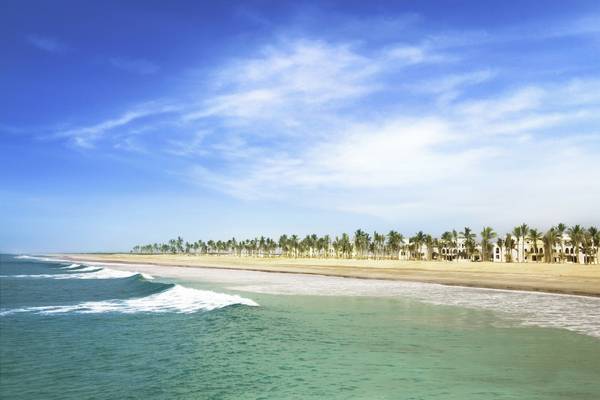 Strand mit Palmen und Hotels am Salalah Rotana Resort