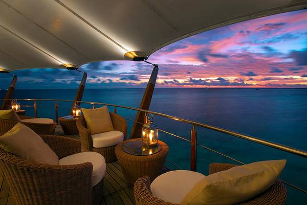 Aussicht auf das Meer vom Baros Maldives Resort mit einem gerahmten Sonnenuntergang.