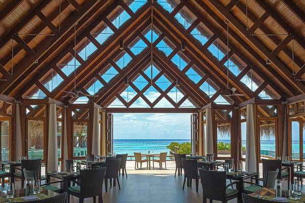 Innenansicht des Restaurants im Baros Maldives Resort mit Blick auf das Meer und die Inseln.