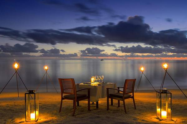 Tisch mit Kerzen auf dem Strand im Baros Maldives Resort