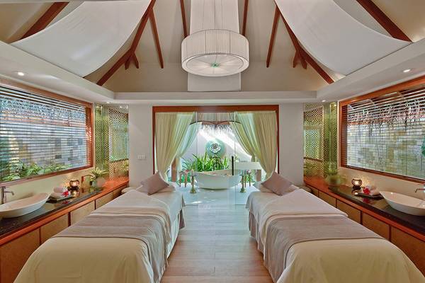 Spa-Behandlungsraum im Baros Maldives Resort mit zwei Behandlungsliegen und Badewanne.