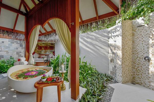 Outdoor Badezimmer im Baros Maldives Resort mit Badewanne, Dusche und Pflanzen.