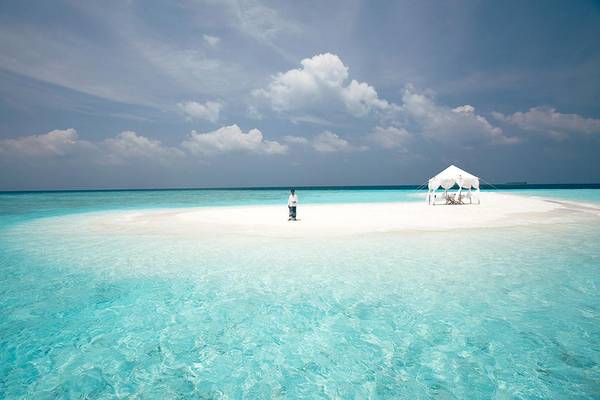Eine Insel mit einem weißen Zelt im Wasser des Baros Maldives Resorts.