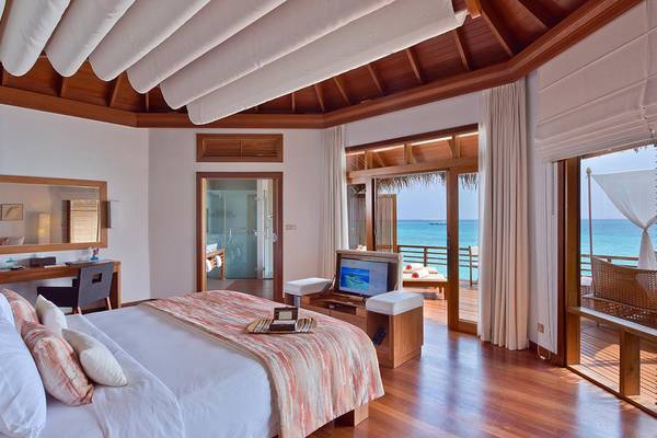 Innenansicht des Baros Maldives Resort Schlafzimmers mit Blick auf das Meer.
