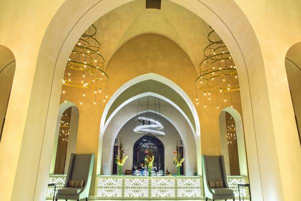Foyer des Salalah Rotana Resorts mit zwei Sesseln und einer Theke.