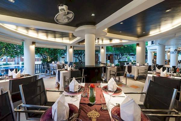 Innenansicht des Restaurants im Dara Samui Beach Resort mit gedeckten Tischen und Stühlen.