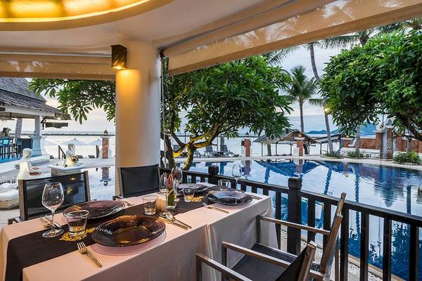 Ein Tisch auf der Terrasse des Dara Samui Beach Resort mit Blick auf den Pool.