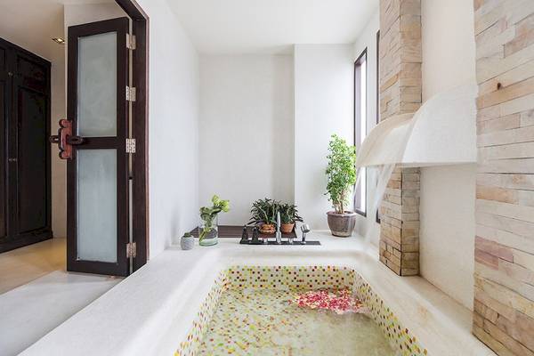 Badezimmer im Dara Samui Beach Resort mit bemalter Wanne und Pflanzen.