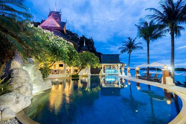 Nachtansicht des Swimmingpools des Dara Samui Beach Resort mit Lounge-Stühlen und Palmen