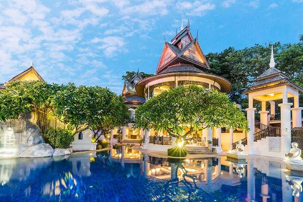 Außenpool des Dara Samui Beach Resorts bei Nacht mit beleuchteten Gebäuden und Wasserfall