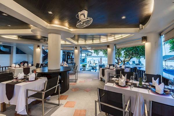 Innenansicht des Restaurants im Dara Samui Beach Resort mit Blick auf den Pool und das Meer.