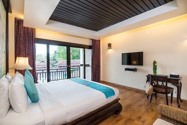 Hotelzimmer im Dara Samui Beach Resort mit Bett, Schreibtisch und Fernseher.
