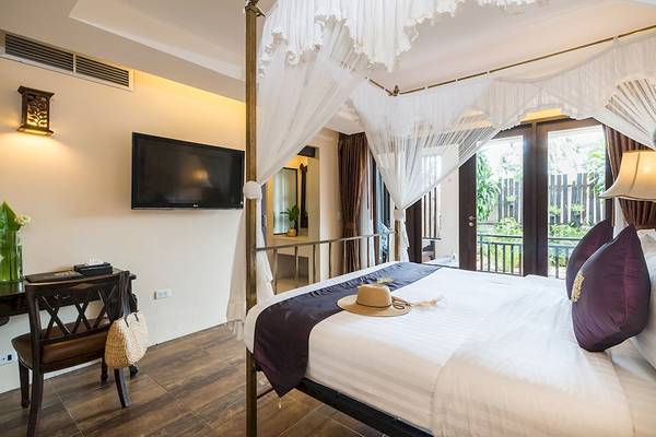 Schlafzimmer im Dara Samui Beach Resort mit Himmelbett, Fernseher und Balkon