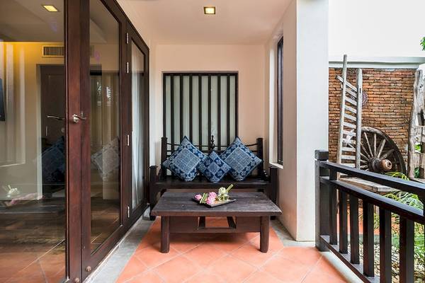 Innenansicht eines Balkons des Dara Samui Beach Resorts mit einem Couchtisch und Kissen.