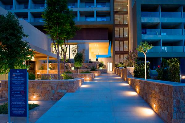 Foto des Eingangsbereichs des Amada Colossos Resorts bei Nacht mit Beleuchtung und Hinweisschildern.