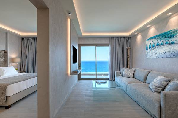 Hotelsuite des Amada Colossos Resorts mit Meerblick, Bett, Sofa und Fernseher.