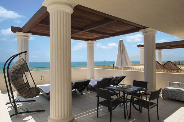 Terrasse des Delphin Diva Premiere Hotels mit Blick auf das Meer und weißen Säulen.