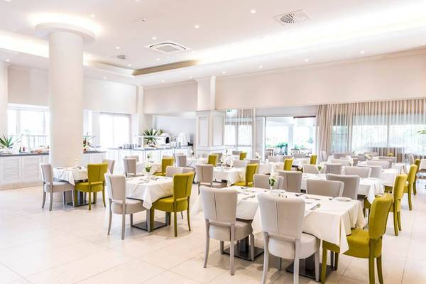 Frühstücksraum des Nissiana Hotels mit gedeckten Tischen und Stühlen.