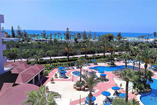 Luftaufnahme des Nissiana Hotel Resorts mit Swimmingpools, Sonnenliegen und Blick auf das Meer.