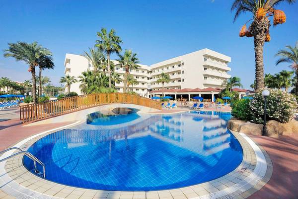 Außenbereich des Nissiana Hotels mit großem Schwimmbad und Sonnenliegen