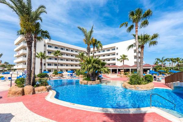 Außenbereich des Nissiana Hotels mit Swimmingpool und Sonnenliegen.