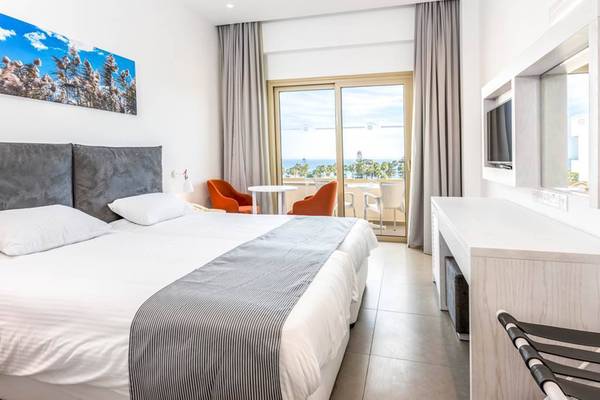 Doppelzimmer mit Meerblick im Nissiana Hotel, mit Bett, Sesseln und Balkonzugang.