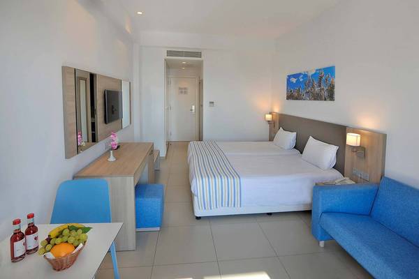 Zimmer im Nissiana Hotel mit zwei Betten, Tisch, Stühle und ein Fernseher.