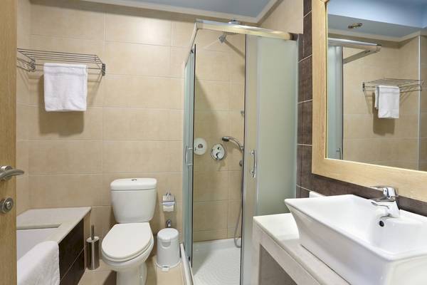 Badezimmer mit Dusche, WC, Waschbecken und Spiegeln.