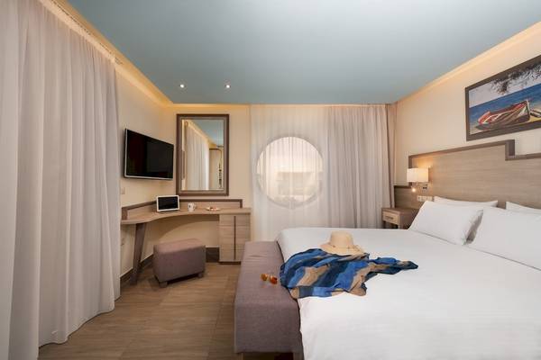 Hotelzimmer im Star Beach Village & Water Park mit Bett, Fernseher und Dekor.