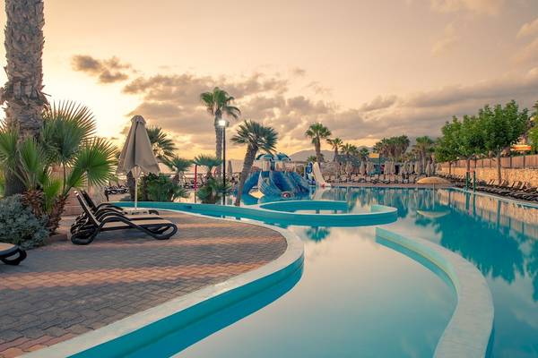 Außenpool des Star Beach Village & Water Park mit Wasserrutschen und Sonnenliegen.