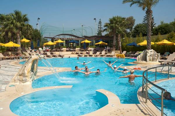 Star Beach Village & Water Park Pool mit vielen Schwimmern und Sonnenschirmen.