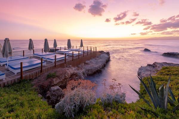 Sonnenuntergang am Star Beach Village & Water Park mit Liegen und Sonnenschirmen am Wasser