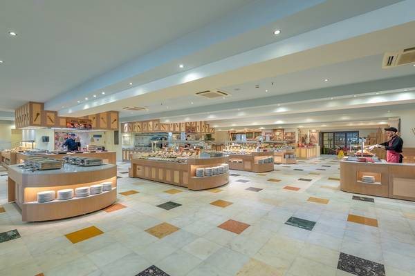 Innenansicht des Restaurants im Star Beach Village & Water Park mit mehreren Buffets und gedeckten Tischen.