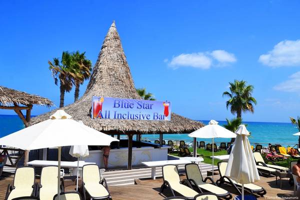 Strandbar im Star Beach Village und Water Park mit Sonnenschirmen und Liegen am Meer.