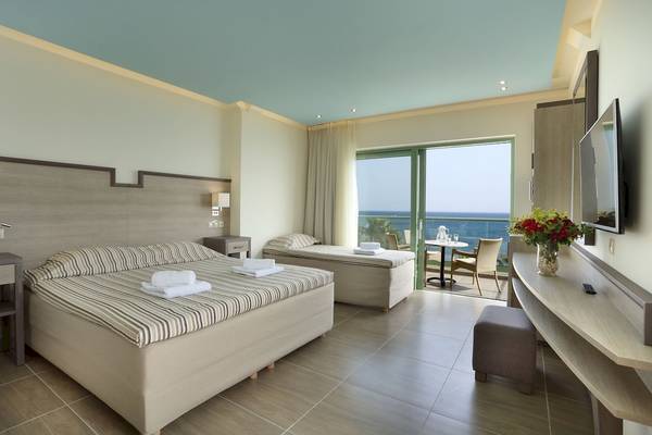 Hotelzimmer im Star Beach Village & Water Park mit Meerblick, zwei Betten, Tisch und Fernseher.