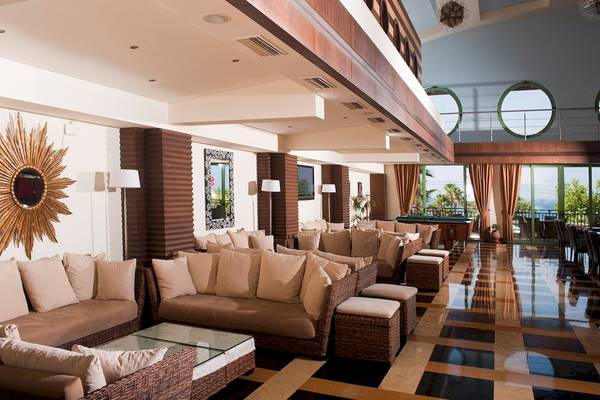 Lobby des Star Beach Village & Water Park Hotels mit Sofas, Lampen und einer Sonnenuhr.