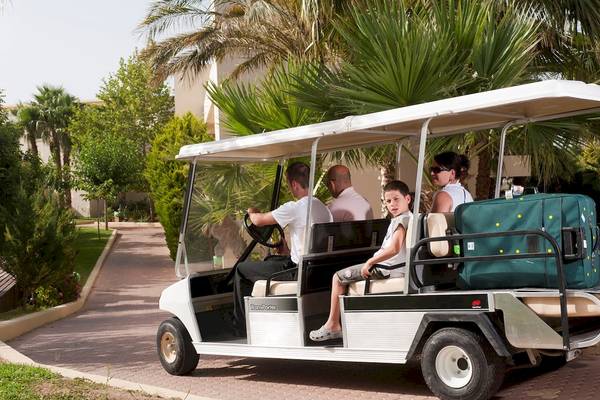 Familie fährt mit einem Golfwagen vor dem Star Beach Village & Water Park Hotel