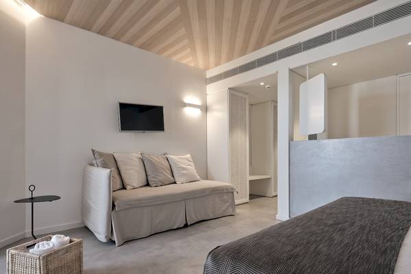 Zimmer im Caravel Hotel mit Sofa, Fernseher und Bett