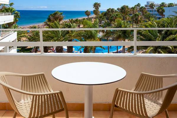 Hotelbalkon mit Tisch und Blick auf das Meer und den Pool im Sol Lanzarote All Inclusive Hotel.