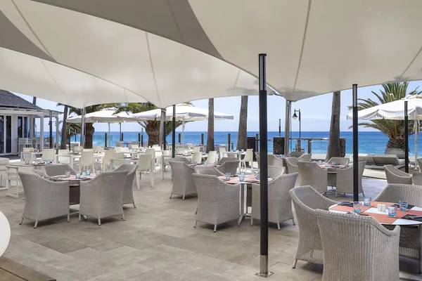 Außenterrasse des Sol Lanzarote All Inclusive Hotels mit Meerblick und weißen Sonnenschirmen.