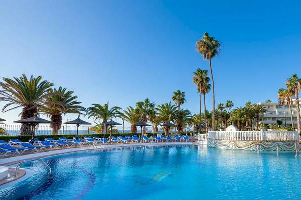 Außenpool des Sol Lanzarote All Inclusive Hotels mit Lounge-Stühlen und Palmen.